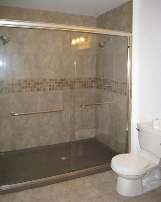 Walk in shower with glass doors and tile